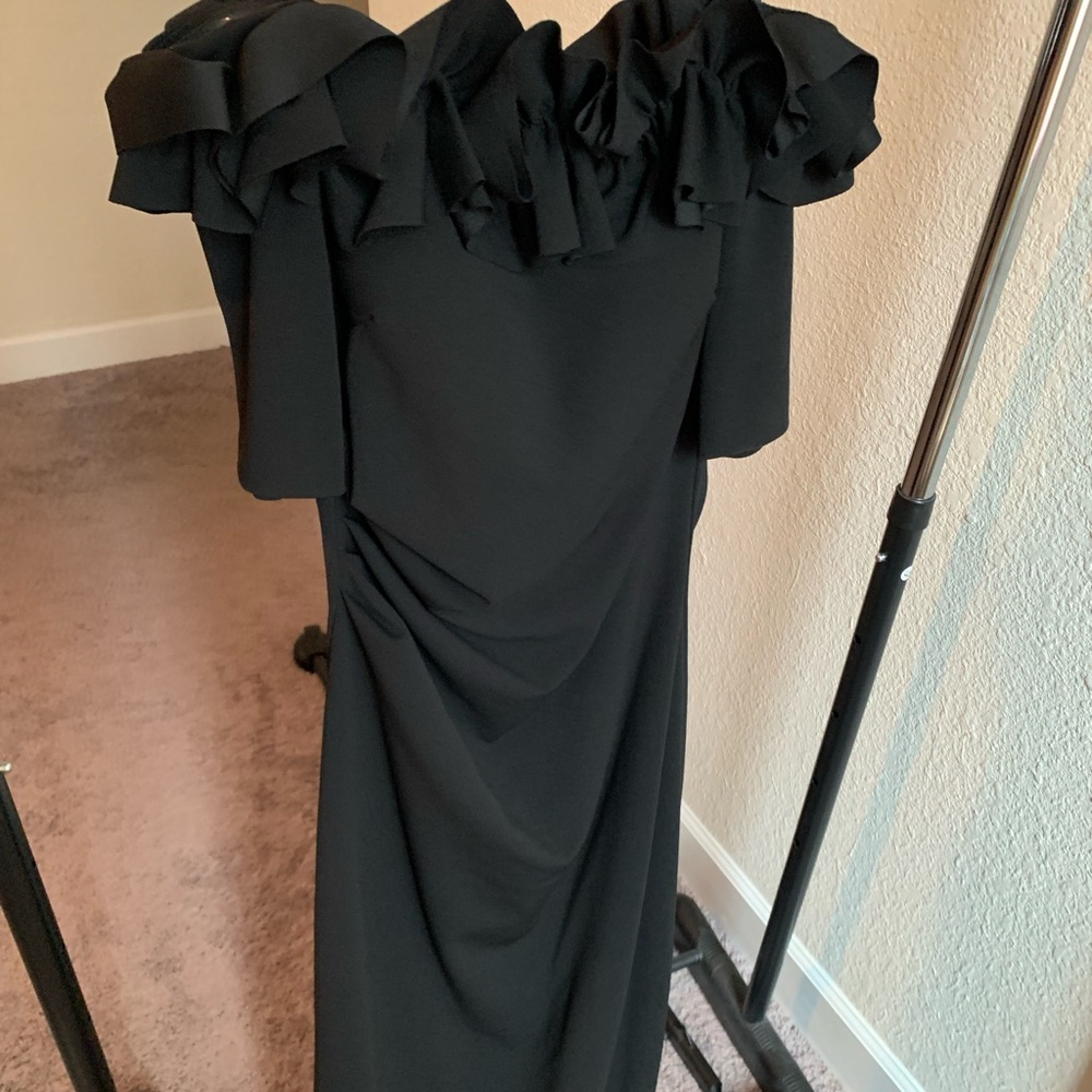 Xscape black formal gown with off the shoulders neckline and short sleeves.